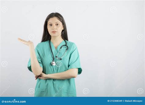 Young Confident Nurse Holding Her Hand Up And Looking At Camera Stock