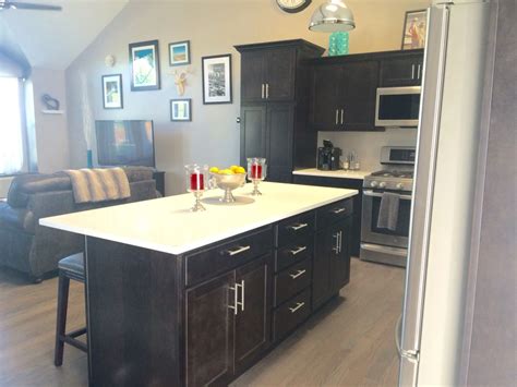 This layout was a result of the more green patterned bar stools sit at a dark wood kitchen island that complements with the upper cabinets. Small spaces: Open Concept: Kitchen and living room. Dark ...