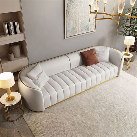 A Living Room With A White Couch And Two Lamps On Either Side Of The Couch