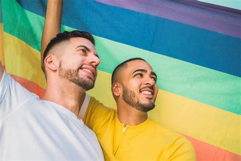 free photo gay couple embracing and showing their love with rainbow flag