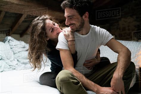 Romantic Couple Sitting On Bed Hugging Stock Photo Dissolve