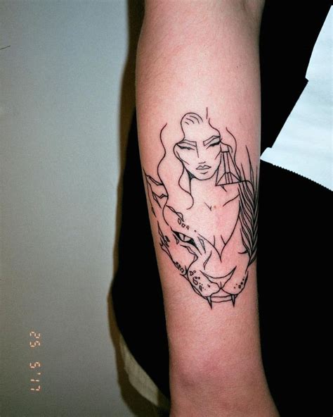 A Womans Arm With A Black And White Tattoo Design On The Left Forearm