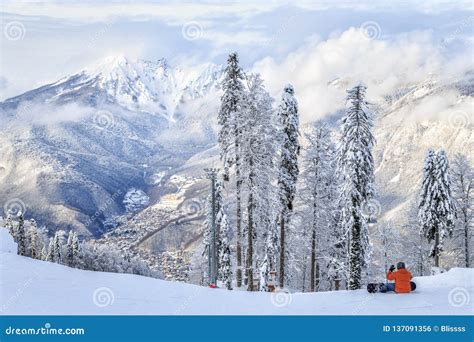 A Snowboarder Sitting On The Snowy Winter Mountain Slope Of Sochi Ski