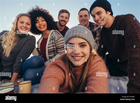 Beautiful Young Woman Taking Selfie With Friends Sitting Around At The Beach Group Of Friends