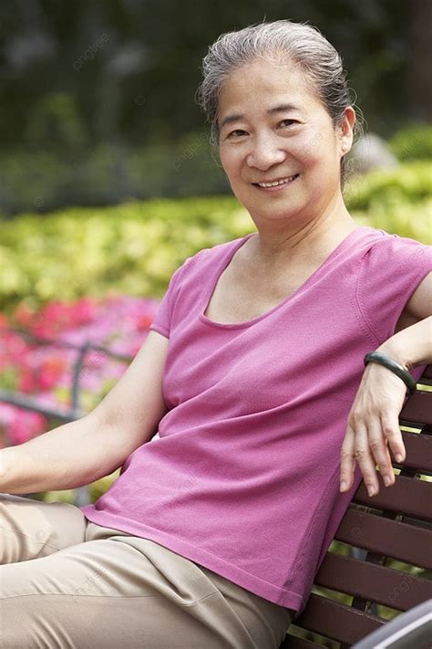 senior chinese woman relaxing on park bench background looking woman hong background image