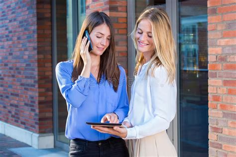 Two Young Women Standing Outside With Tablet Stock Image Image Of