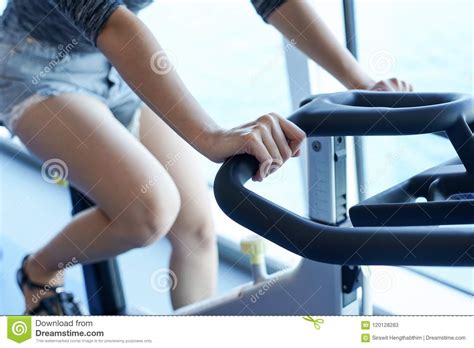 Close Up Women Working Out In Gym On The Exercise Bike Stock Image