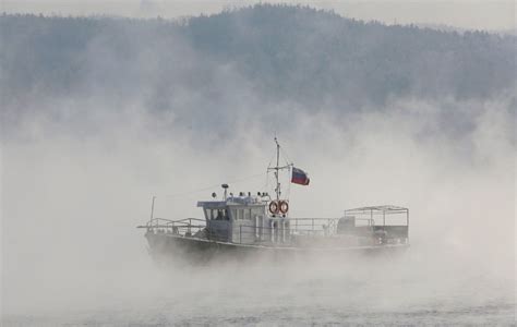 A Motor Boat Sails Through A Frosty Evaporation Along The Yenisei River