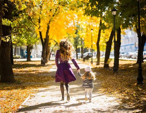 Mother And Her Child Girl Playing Together On Autumn Walk In Nature