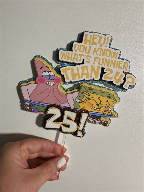 Someone Is Holding Up A Cake Topper With The Number Twenty Five On It