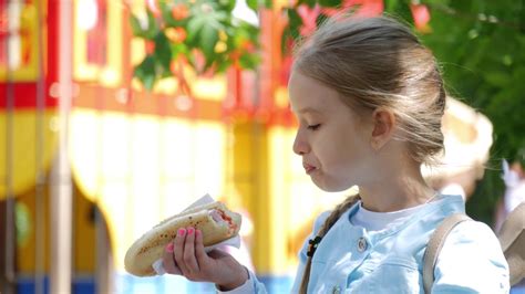 Beautiful Young Girl Eating A Hot Dog In A Park Stock Video Footage 00