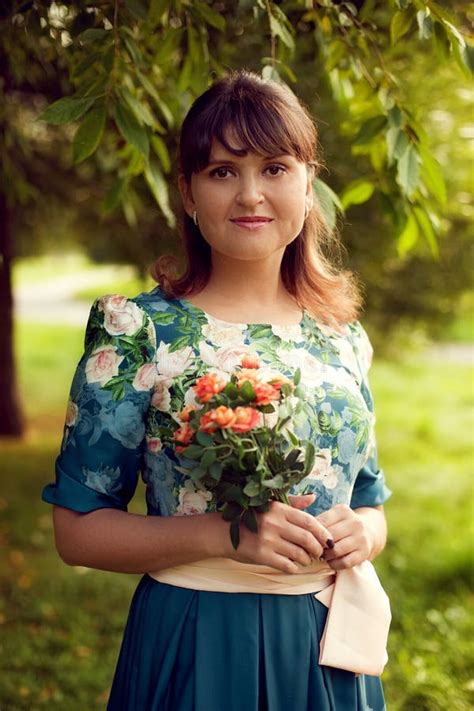 Young Beautiful Woman In Floral Dress Posing In Park With A Bouquet Of Flowers Stock Image