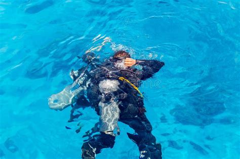 Scuba Divers Dive Into The Clear Blue Water In The Sea Stock Image