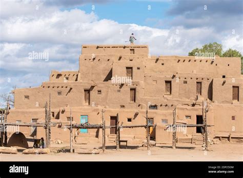 Man On The Roof Of Adobe Mud Brick Houses In The Historical Native