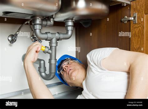Plumber At Work In A Kitchen Fixing A Sink Stock Photo Alamy