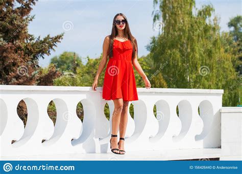 Young Beautiful Woman In Red Dress On The Summer Street Stock Photo