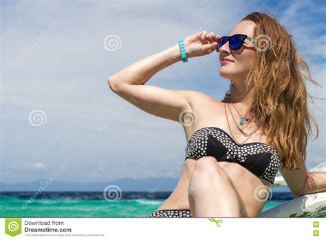 Young European Woman With Sunglasses Is Sitting On The Boat In Tropical
