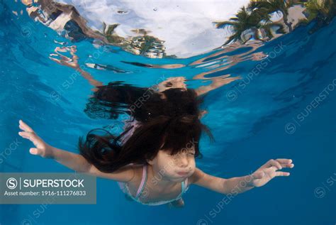 4 Year Old Girl Playing Underwater In A Swimming Pool Superstock
