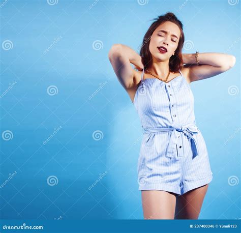 Young Pretty Girl In Sunglasses Posing Happy Smiling On Blue Background