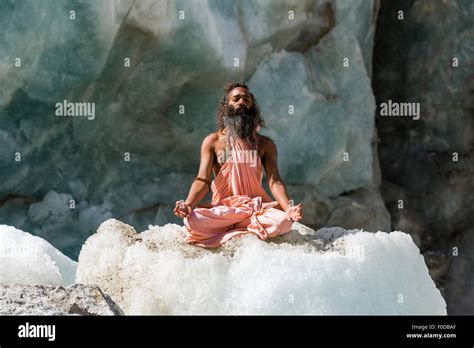 A Sadhu Holy Man Is Sitting And Meditating In Lotus Pose Stock Photo