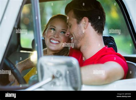 Young Couple Sitting In Vintage Pick Up Truck Guy With His Arm Around