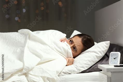 Scared Woman Hiding Under Blanket On A Bed In The Night Buy This