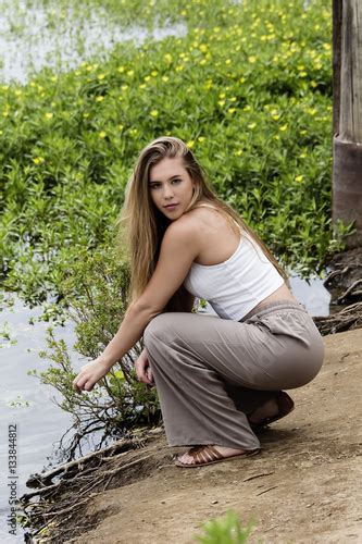 Caucasian Teen Girl Squatting On River Bank Buy This Stock Photo And