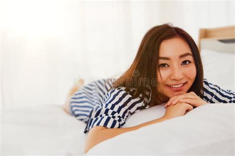 asian teen girl lazing on the bed looking at the cute camera stock image image of asian