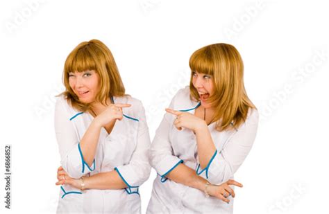 Two Girls In Nurse Overalls Point Finger At Each Other Stock Photo