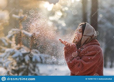 Beautiful Stylish And Young Girl Blowing The Snow From Her Hands In