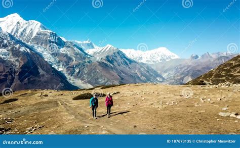 ice lake a couple walking along a pathway with the view on annapurna chain stock image image