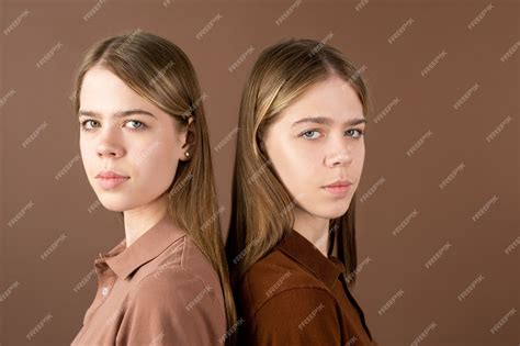 Dos Lindas Chicas Gemelas Adolescentes Rubias En Camisas Marrones Mirando A La Cámara Mientras