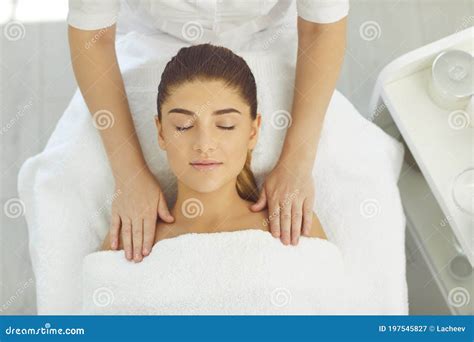 Hands Of Cosmetologist Making Facial And Shoulders Massage For Smiling Woman In Wellness Beauty