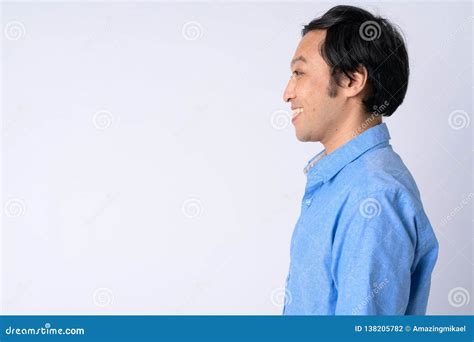 Profile View Of Happy Japanese Businessman Smiling Against White