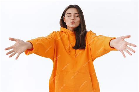 Free Photo Romantic Gorgeous Girlfriend In Orange Hoodie Close Eyes And Fold Lips For Mwah