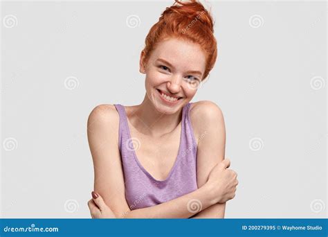 Indoor Shot Of Friendly Looking Timid Woman In Purple Top Smiles From Happiness And Joy Hugs