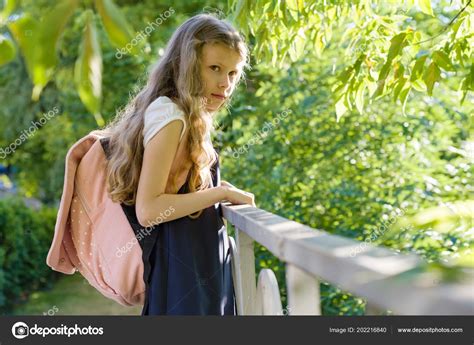 Schülerin Blond Mit Rucksack Schuluniform Zaun Auf Dem Schulhof Zurück Stockfotografie