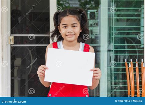 Cute Asian Girl Wear Red Clothes Hold A Blank White Paper And Smiling