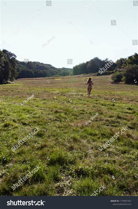 Naked Woman Running Through Green Meadow Stock Photo