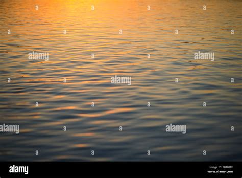 Sunset Reflected On Surface Of Water Stock Photo Alamy