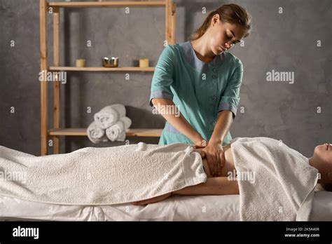 female masseur massaging female belly in medical spa center lymphatic drainage manual massage