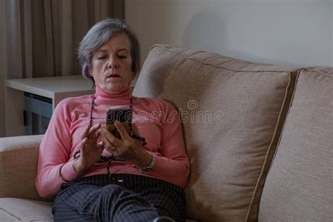 mature woman lying on a sofa checking her cell phone stock image image of indoor alone 235408539