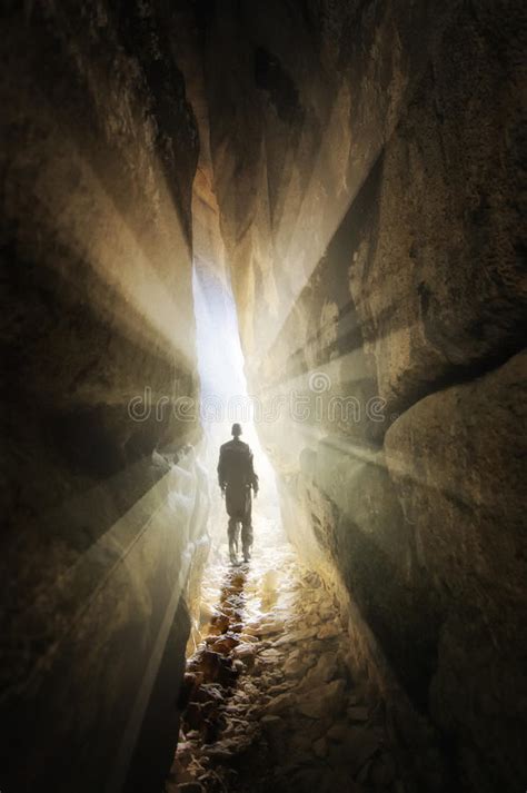 Man Walking Out Of A Cave Into The Light Stock Photos