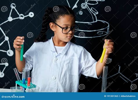 Asian American Female Child Scientist Holding Tube During A Experiment