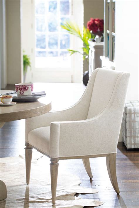 The seat is a small padded cushion covered in faux leather. Dining Arm Chair | Bernhardt