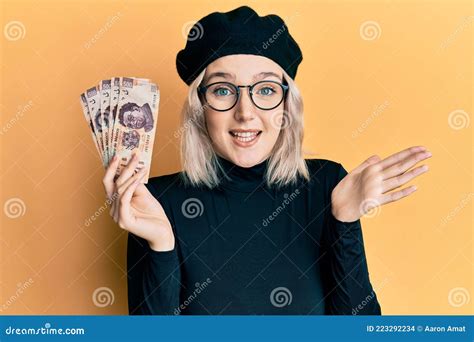 Young Blonde Girl Holding Mexican Pesos Celebrating Achievement With