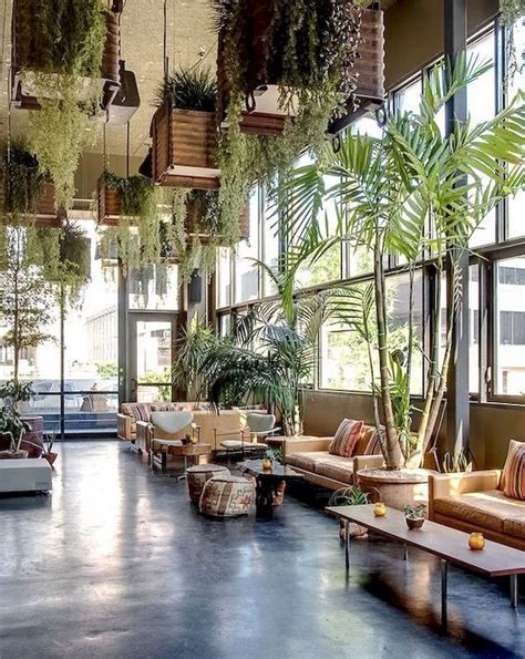 Plants Hanging From The Ceiling And Pot Plants Enhance This Lobby Space