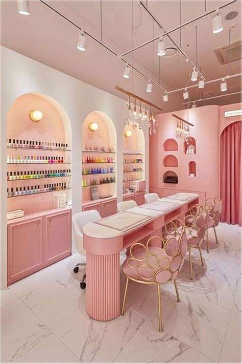 The Interior Of A Nail Salon With Pink Walls And Marble Counter Tops