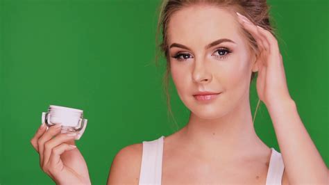 Young Woman Applying Cream On Her Face And Looking On Cream Stock Video