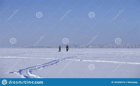 Fishermen Walking Along The Frozen Lake Winter Fishing Stock Photo